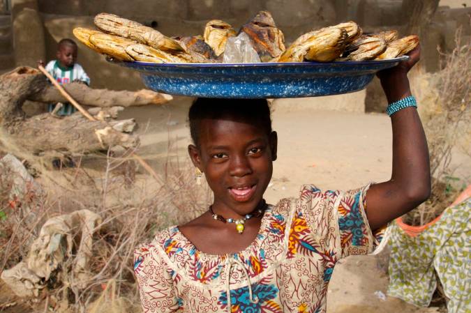 A girl sells fish in a village by the Niger River, Mali, Africa