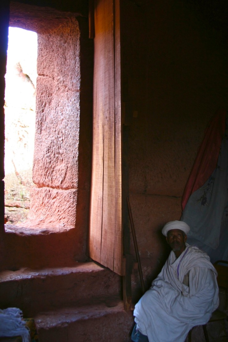 Priest sits by a doorway, Lalibela, Ethiopia, Africa